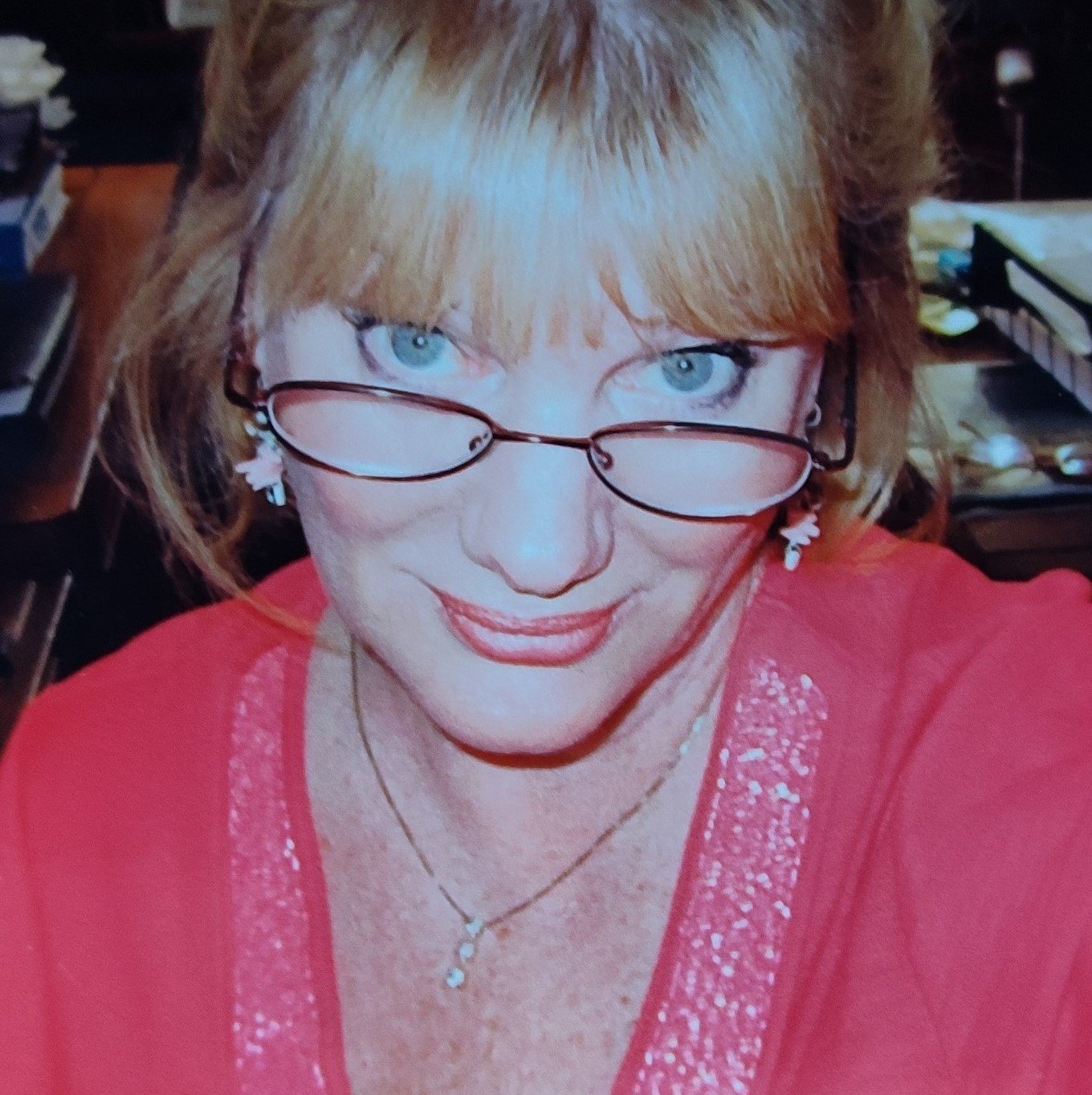 Photo of author Deborah Culver wearing a pink blouse and looking at the camera over her glasses